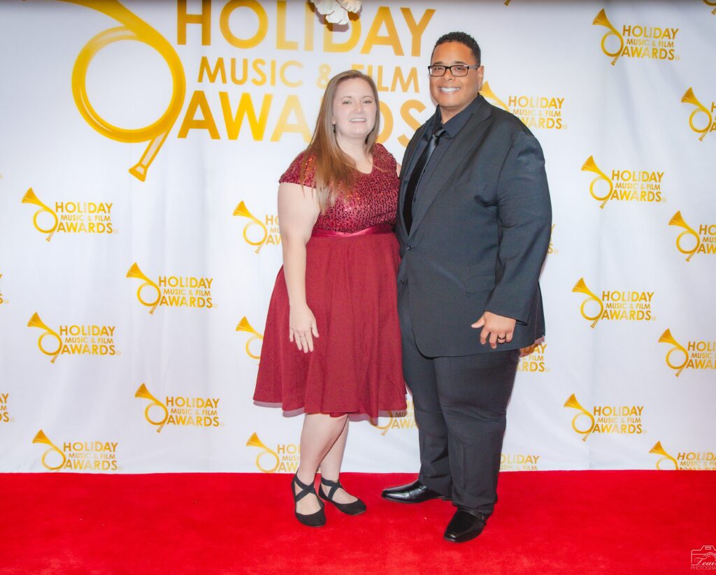 A man and woman posing for a picture on the red carpet.