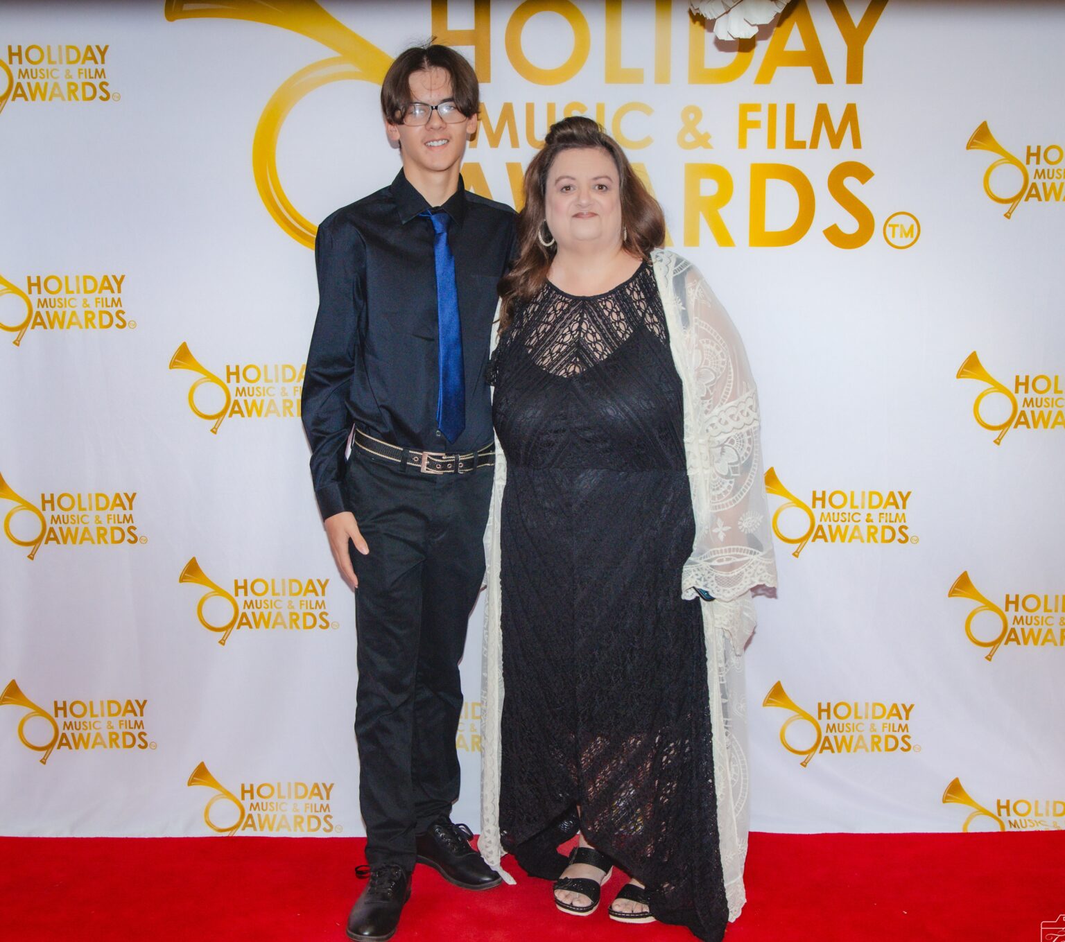 A man and woman posing for the camera on the red carpet.