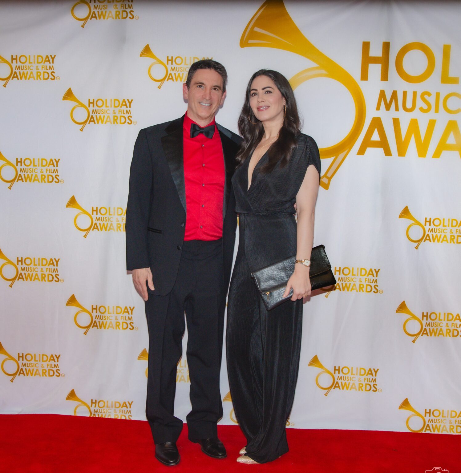 A man and woman posing for a picture on the red carpet.