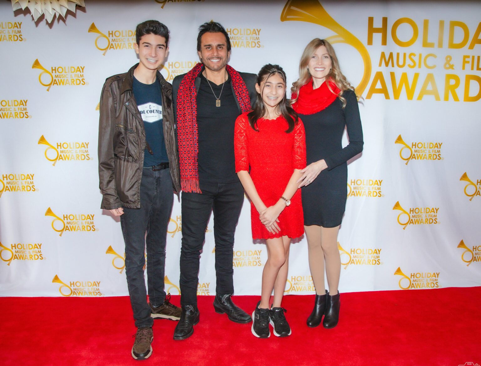 A group of people standing on the red carpet.