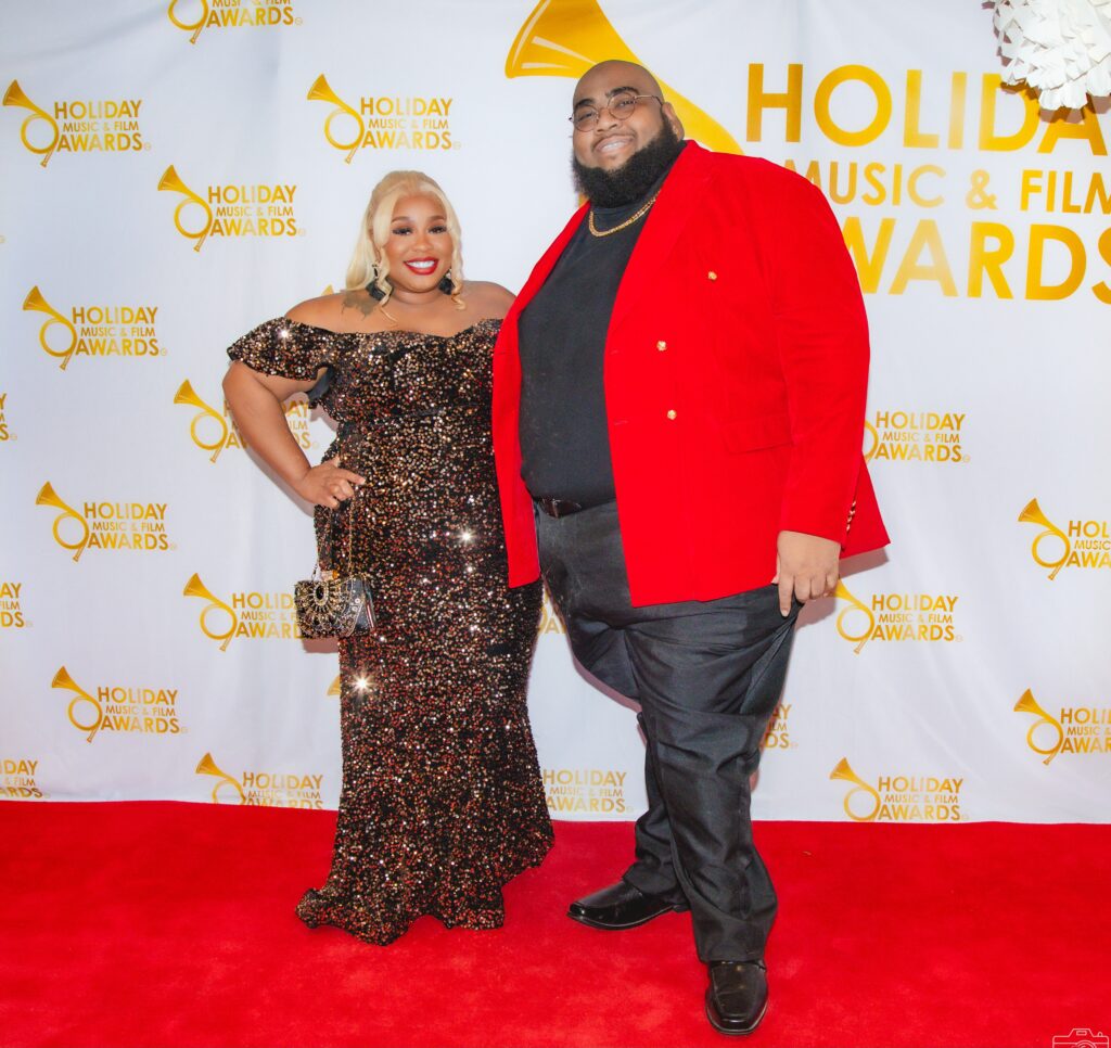 A man and woman posing for the camera on the red carpet.