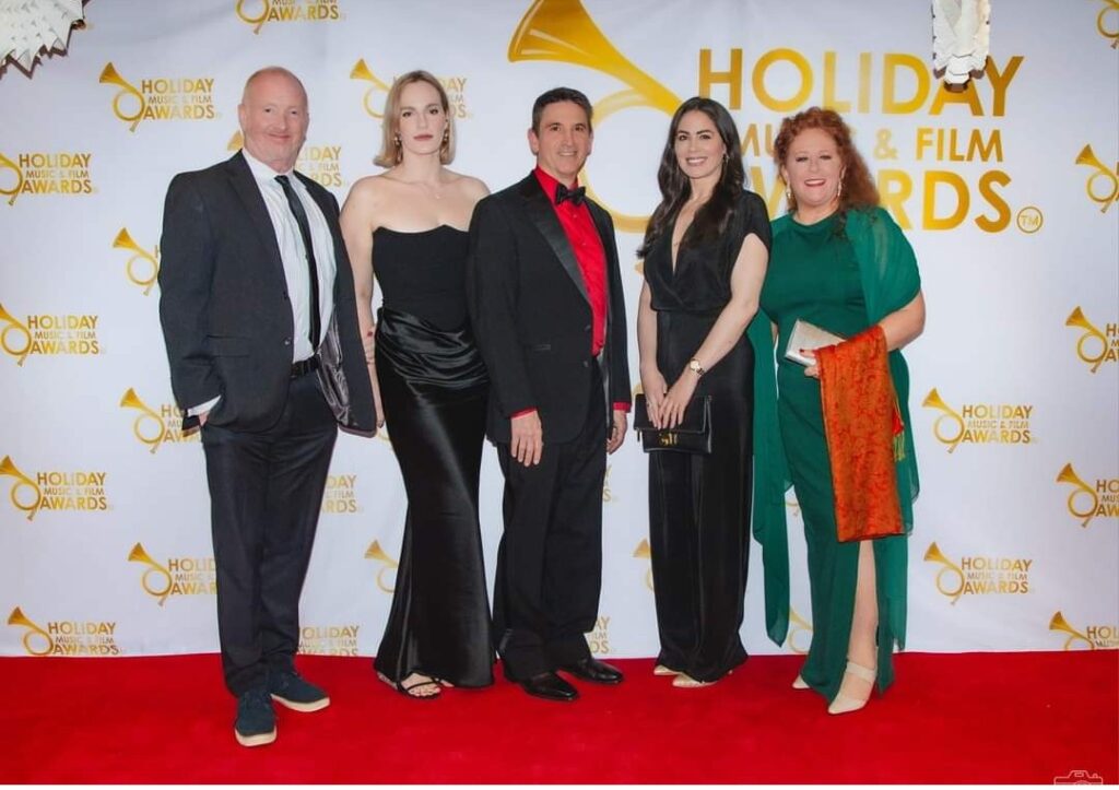 A group of people standing on the red carpet.