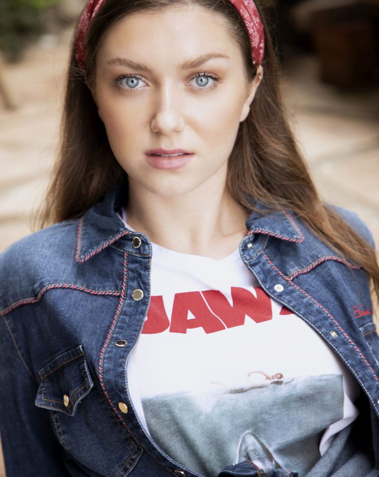 A woman wearing a jean jacket and a t-shirt.